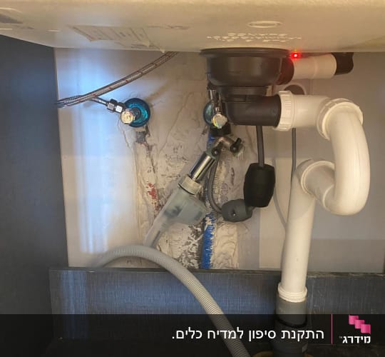 צנרת מתחת לכיור עם חיבורים וצינורות פלסטיק